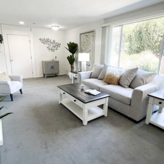 A bright and spacious living room with neutral tones and modern decor.