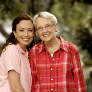 Two women smiling together in an outdoor setting.