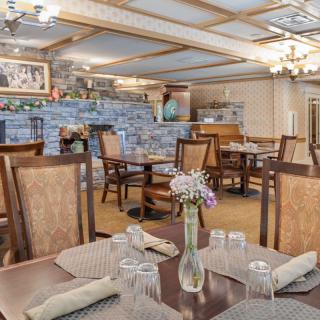 A cozy restaurant interior with neatly arranged tables and chairs, adorned with floral centerpieces.