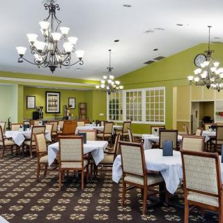 Elegant dining room with neatly arranged tables and chandeliers.