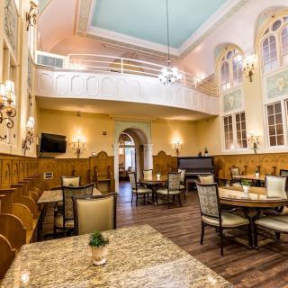 Elegant restaurant interior with high ceilings and classic decor.