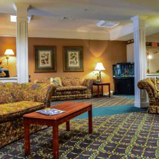 A cozy lobby with comfortable sofas, a wooden table, and warm lighting.