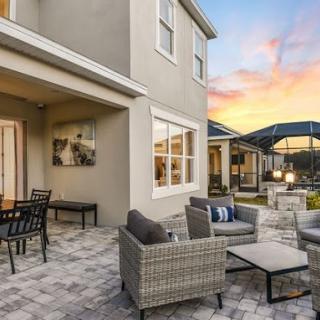 A modern outdoor patio area with comfortable seating, overlooking a beautiful sunset.