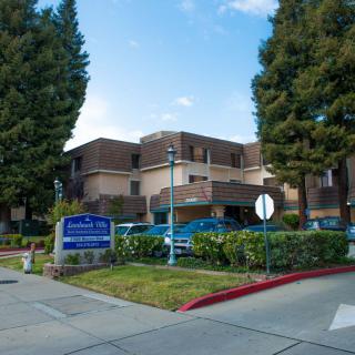 A hospital building surrounded by trees with a clear sky.