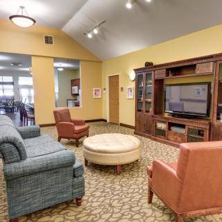 A cozy living room with sofas, armchairs, and a large entertainment center.