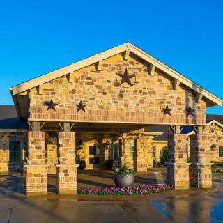 A stone building entrance decorated with star motifs under a clear blue sky.