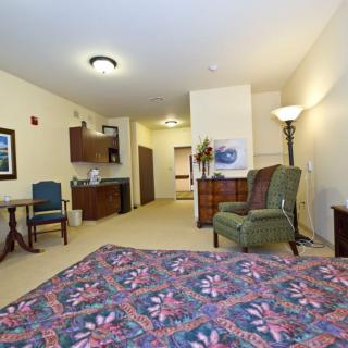 A cozy and spacious bedroom featuring comfortable furniture and warm lighting.