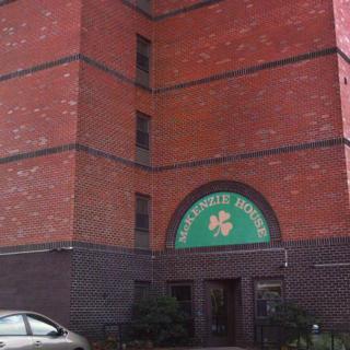 A brick building with an entrance featuring a shamrock design above the doorway.