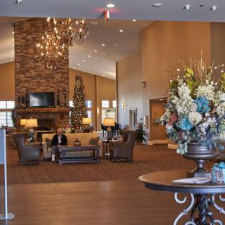 A spacious and elegantly decorated lobby featuring a chandelier, fireplace, and ample seating.