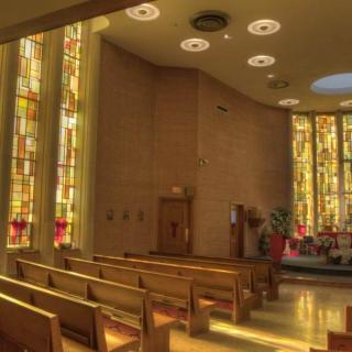A serene church interior with stained glass windows and wooden pews.