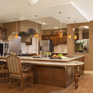 A modern kitchen with wooden cabinets, an island counter, and stainless steel appliances.