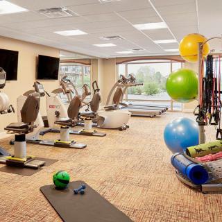 A modern gym equipped with exercise machines, yoga mats, and fitness balls.