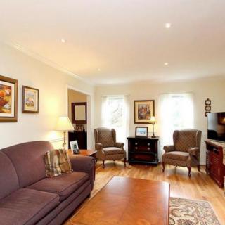 A cozy living room with comfortable seating, artwork on the walls, and a warm ambiance.