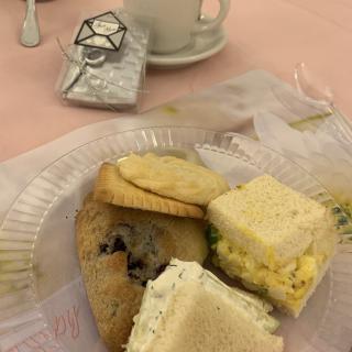 A delightful tea party spread featuring sandwiches and cookies, set on a beautifully arranged table.