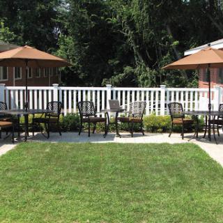 A serene outdoor patio with seating arrangements under umbrellas, perfect for relaxation.