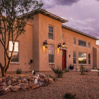 A modern desert-style house with outdoor lighting at dusk.