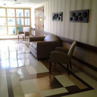 A quiet lobby with comfortable seating and tiled flooring.