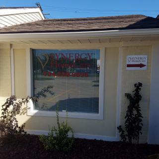 A small building with a large window and a sign on the wall indicating direction.