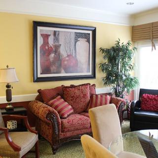 A cozy living room with a sofa, artwork, and an indoor plant.