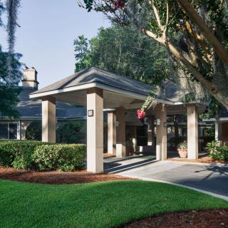 A welcoming entrance to a building, surrounded by well-maintained landscaping and trees.