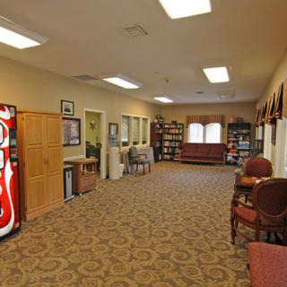 A spacious waiting room with a vending machine and comfortable seating.