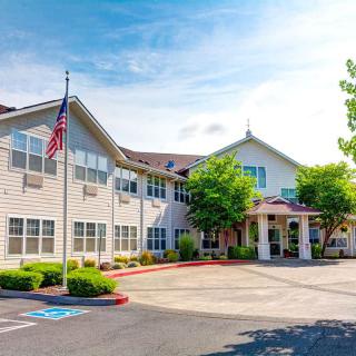 A sunny view of a large, modern building with an American flag in front.