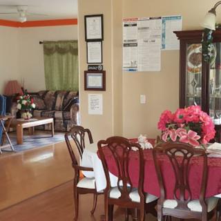A cozy dining area with a table set for guests, connected to a comfortable living room.