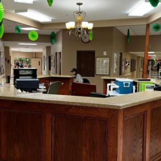 A reception area with wooden desk and office equipment.
