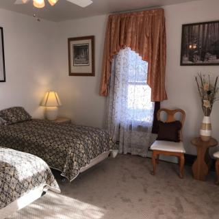A cozy bedroom with twin beds, soft lighting, and elegant decor.