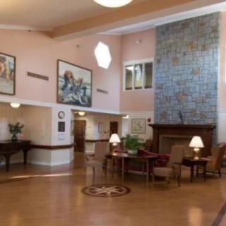A spacious lobby area with comfortable seating, a grand piano, and artwork on the walls.