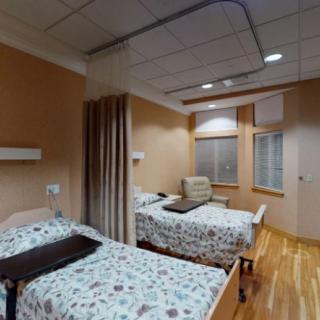 A hospital room with two patient beds and medical equipment.
