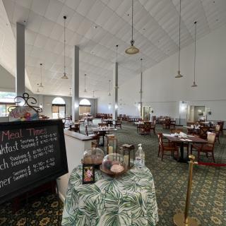 An empty restaurant dining area with neatly arranged tables and a menu board displaying the day's specials.