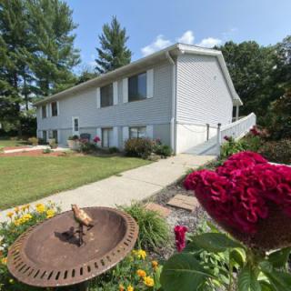 A suburban house with a well-maintained garden and vibrant flowers on a sunny day.