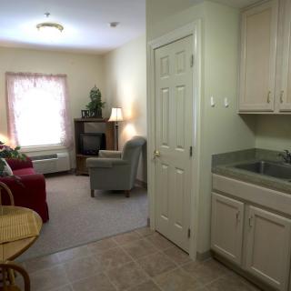 A cozy apartment interior featuring a small kitchen area and a furnished living room.
