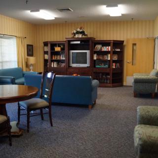 A cozy living room with sofas, a television, and a bookshelf.