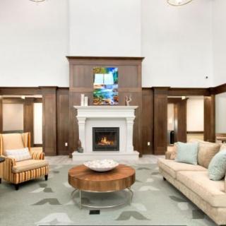 A modern living room featuring a fireplace, a comfortable couch, an armchair, and a stylish coffee table.