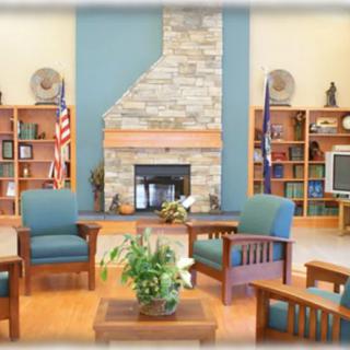 Cozy living room with a fireplace, comfortable seating, and decorated bookshelves.