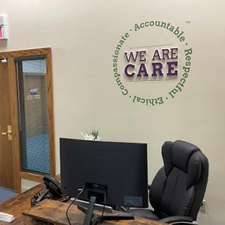 An inviting office space featuring a motivational wall art that emphasizes care and accountability.