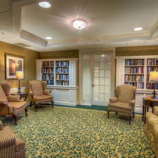 A cozy library reading room with armchairs and bookshelves.