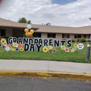 A colorful display celebrating Grandparents Day with decorations including flowers and balloons.