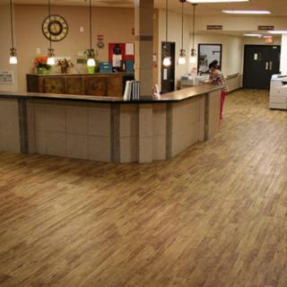 A modern reception area with a front desk and wood flooring.