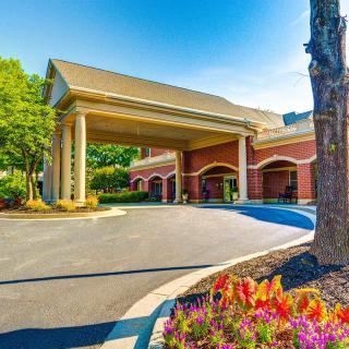 Elegant building entrance with columns and landscaping.