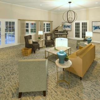A spacious and elegantly decorated living room with a sofa, chairs, tables, and a chandelier.
