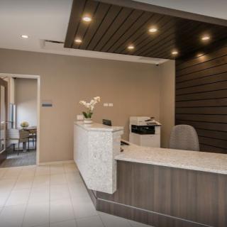 A modern office reception area with a sleek desk and contemporary lighting.