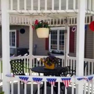A cozy gazebo with outdoor seating decorated in a patriotic theme.