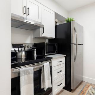A modern kitchen with sleek appliances and white cabinetry.