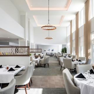 A modern and elegant restaurant interior with stylish lighting and white decor.