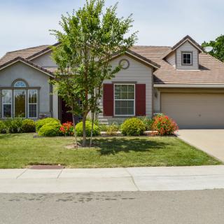 A suburban house with a well-maintained front yard and driveway.