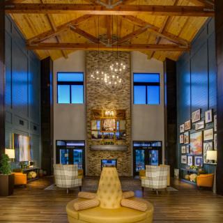 Luxurious lobby with high wooden ceilings and a central fireplace.