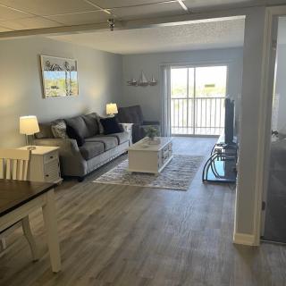 A modern living room with a comfortable couch, coffee table, and television, complemented by a dining area and tasteful decor.